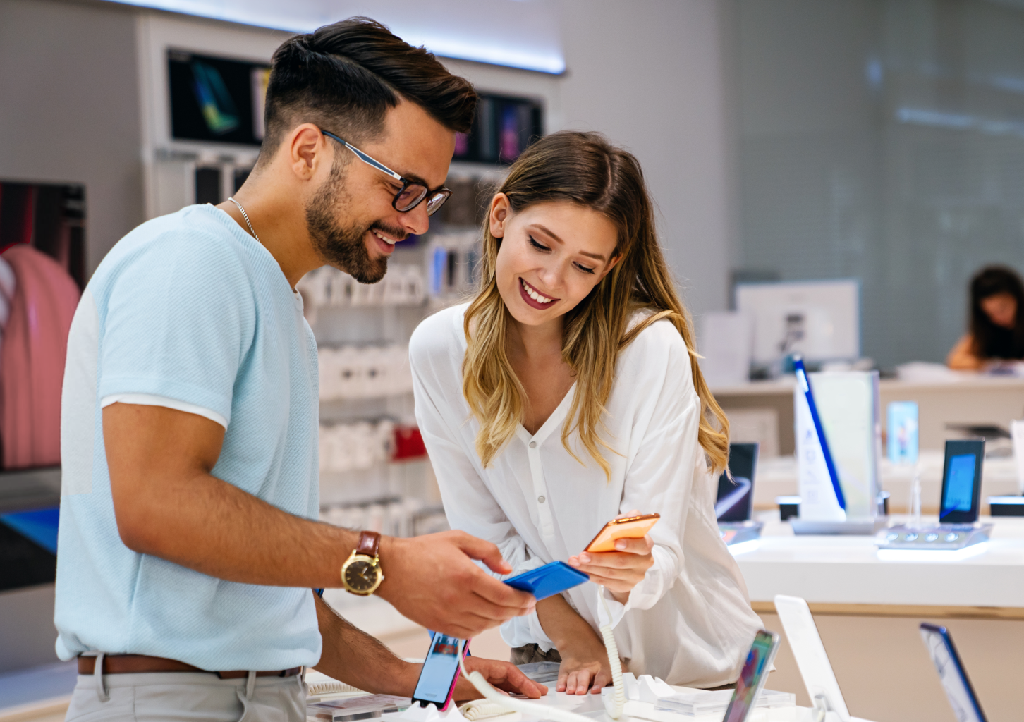 Couple examines phones in store.